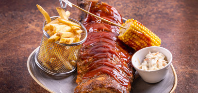 Full Rack BBQ Ribs with Slow cooked full rack of ribs marinated in BBQ sauce. Served with houseslaw, grilled BBQ corn and skin on fries.
