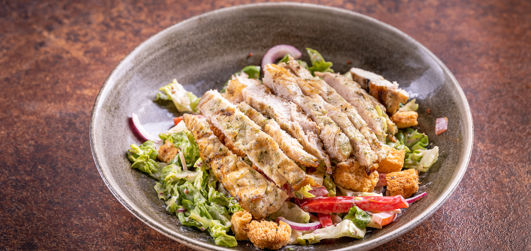 Chicken House Salad with Crisp gem lettuce, red onions, chopped beef tomato, vegetarian Italian cheese, crisp croutons, spring onion and red pepper, all tossed in a honey mustard dressing. Topped with a chargrilled sliced chicken breast.