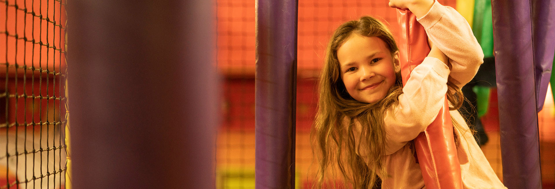 girl with brown hair smiling and playing in soft play at namco funscape