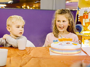 Excited girl and boy celebrating with a birthday cake, surrounded by joy and festivity