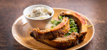 Pork ribs on a plate with salad served with coleslaw