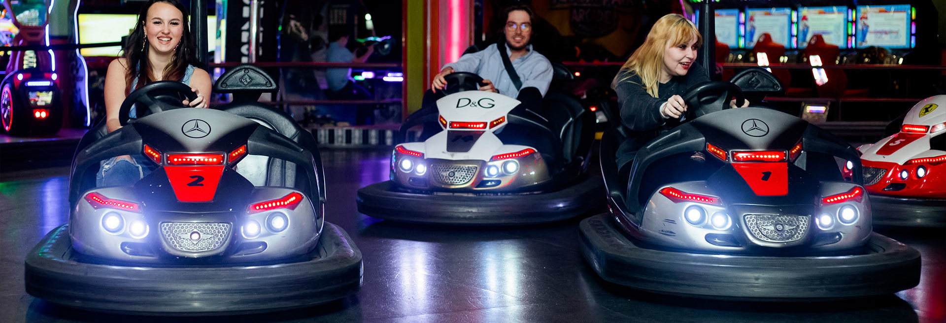 Group laughing while driving around of dodgems at namco funscape 